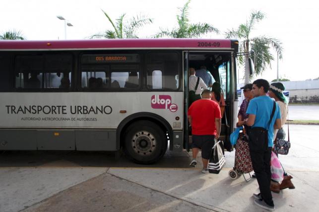People stand in line to board a public bus in San Juan, December 1, 2015. REUTERS/Alvin Baez